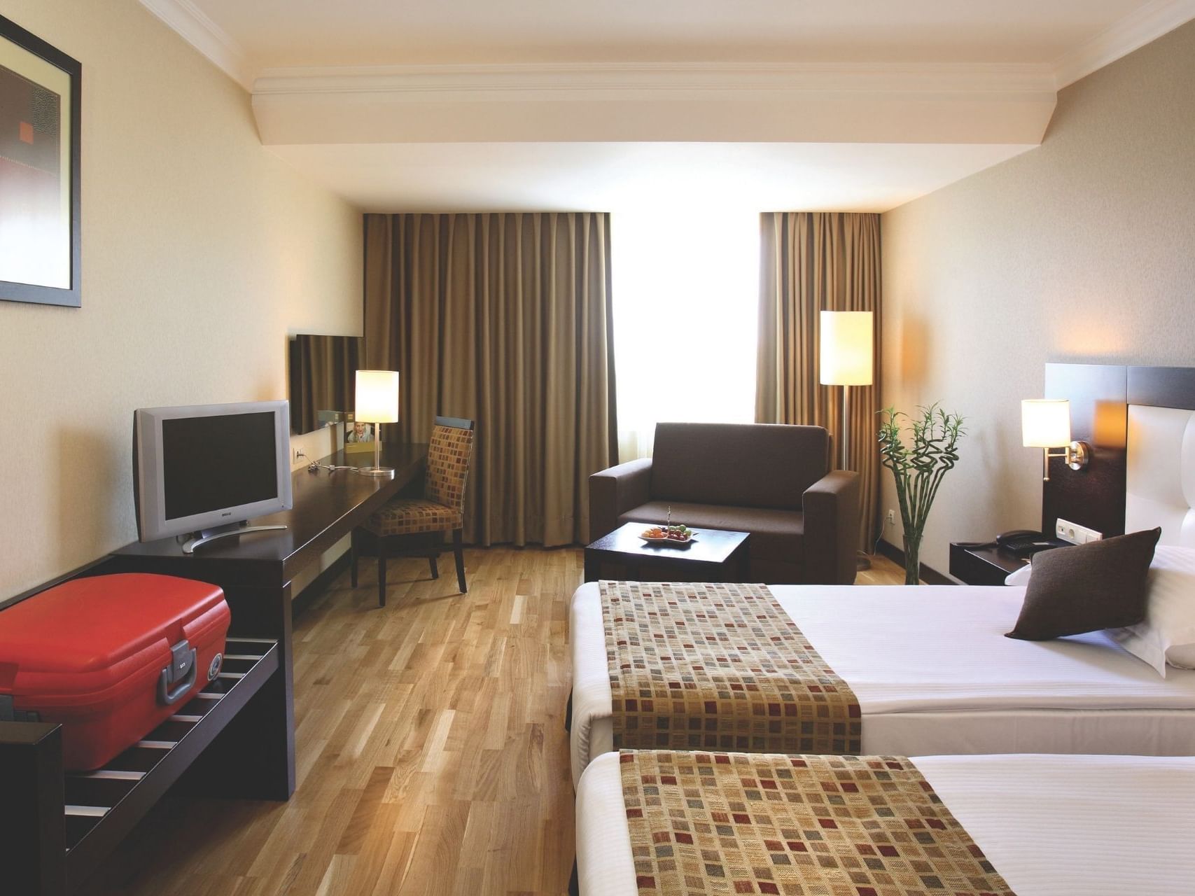 Modern hotel room at Eresin Hotels Topkapi with two single beds, wooden flooring, and natural light from a large window.