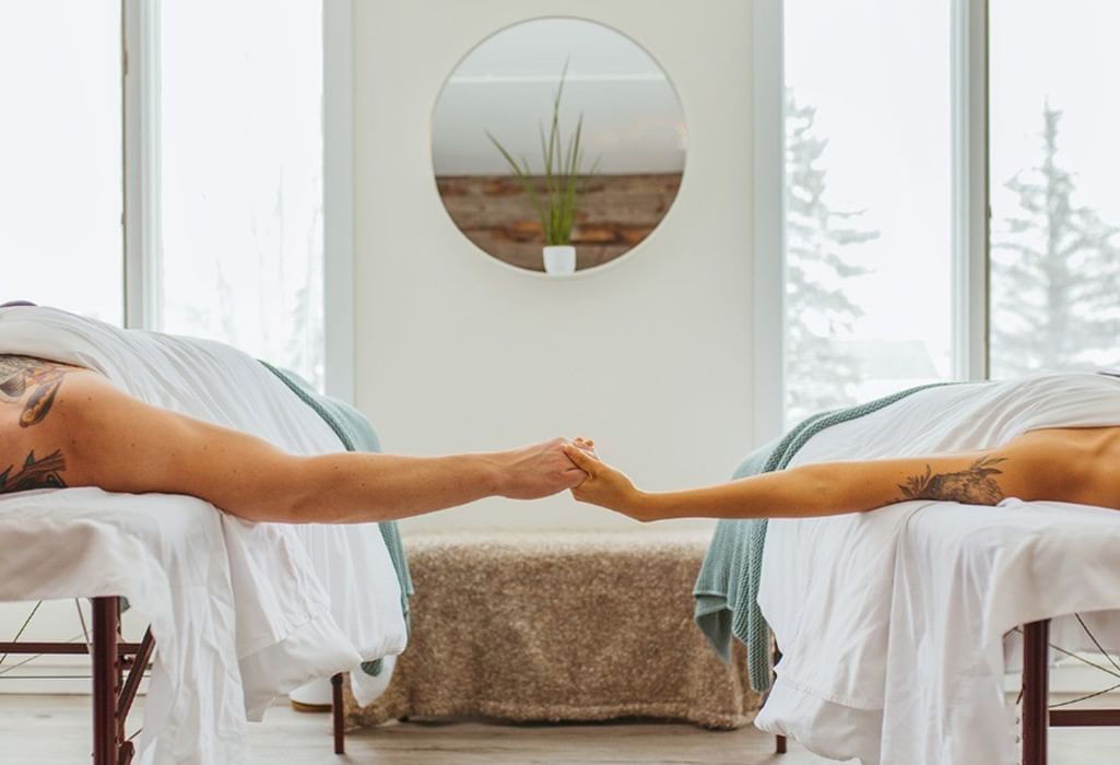 couple holding hands while having a massage treatment