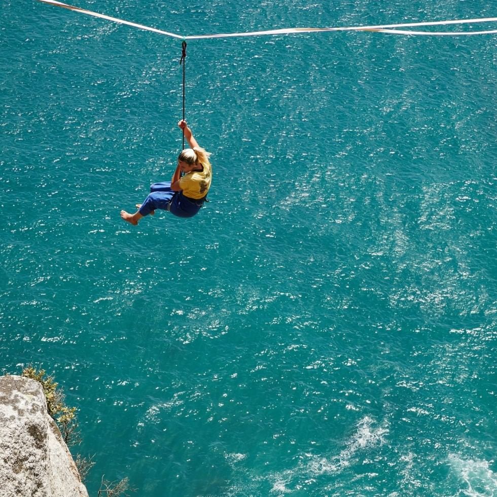 Lady ziplining at above the sea near Falkensteiner Hotels