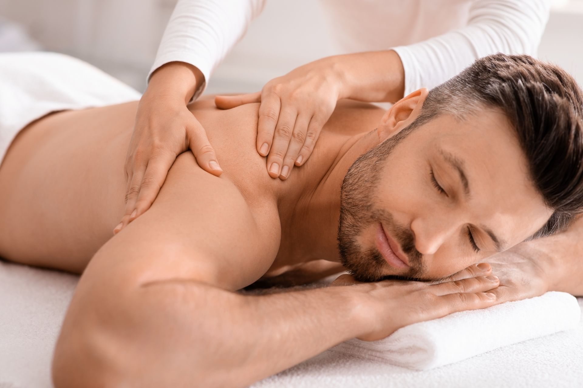 Close-up of a man lying down on a massage table for a body massage in the spa at El Conquistador Resort