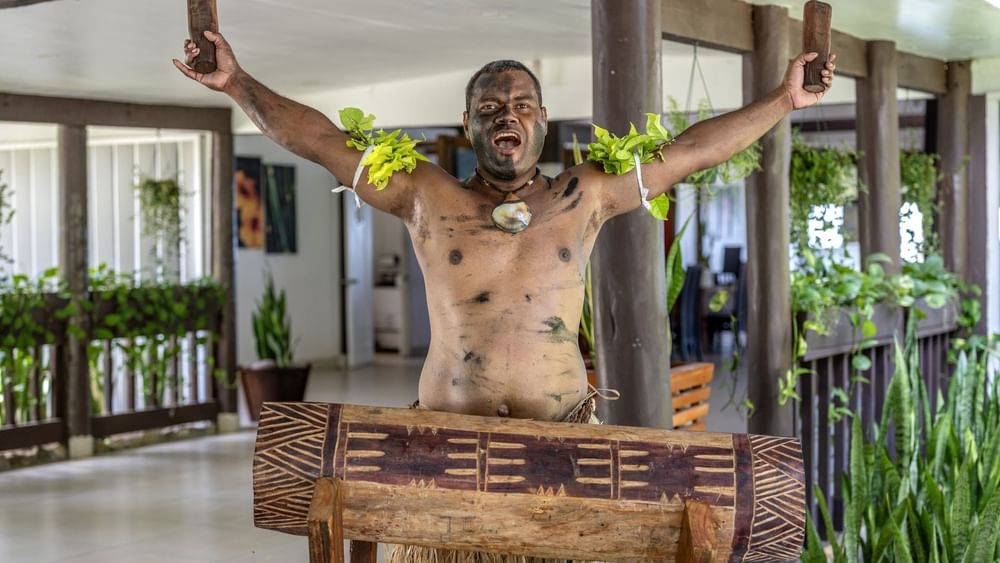 Local traditions performance with painted body and traditional attire at Tambua Sands Beach Resort in Sigatoka.