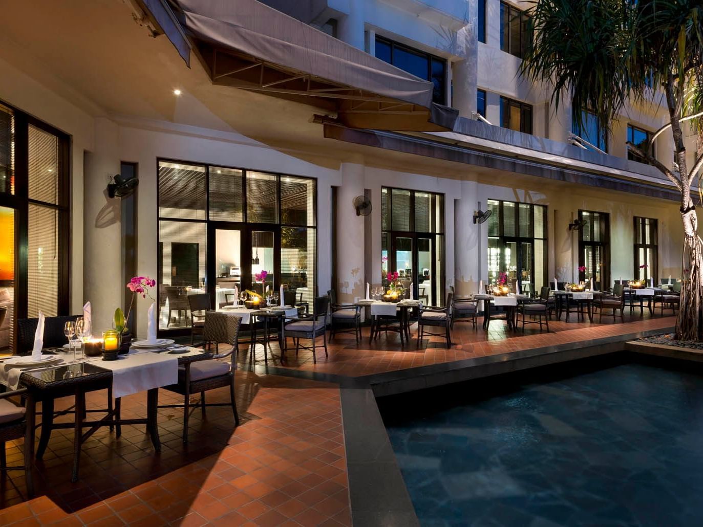 Dining and lounge area arranged by the outdoor pool in Senja at Saujana Hotel Kuala Lumpur