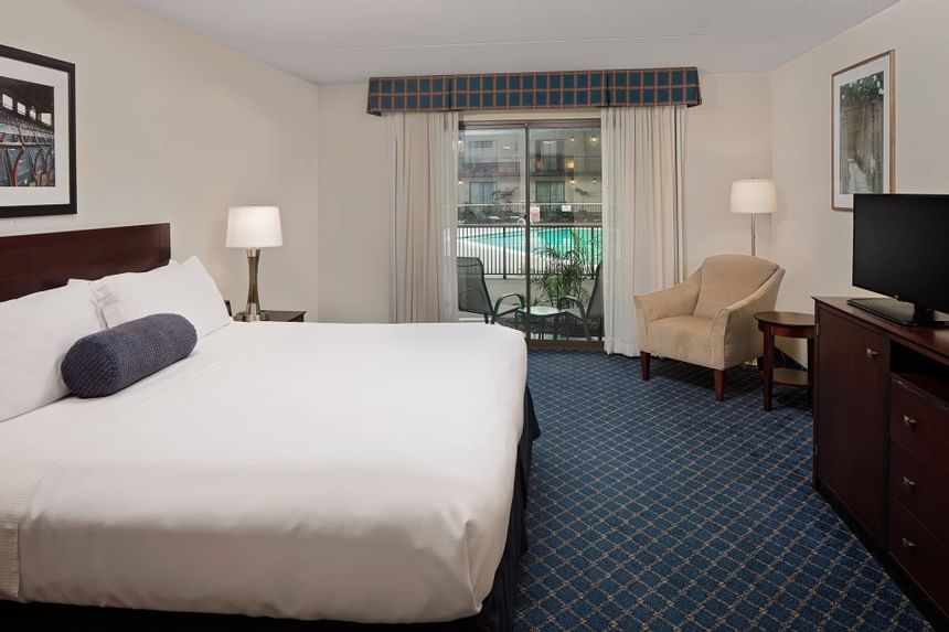 Comfy bed & TV in Pool View King Room at Boxboro Regency Hotel