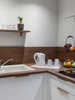 Modern kitchen corner with white cabinets and wooden countertops in the Premium Suite at Warwick Reine Astrid - Lyon