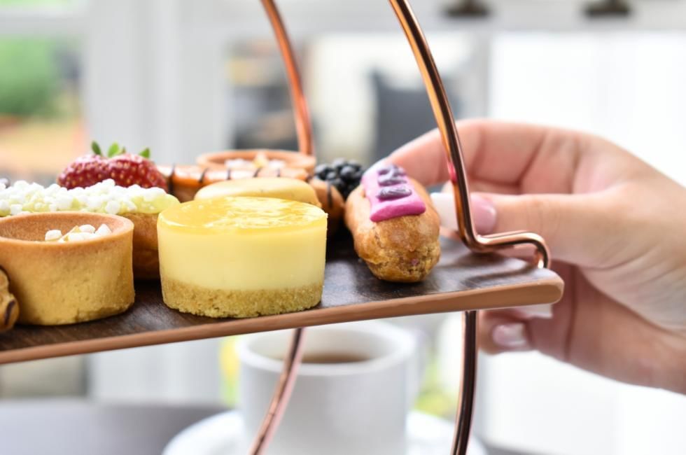 lady picking up treat from afternoon tea dessert selection at gorse hill