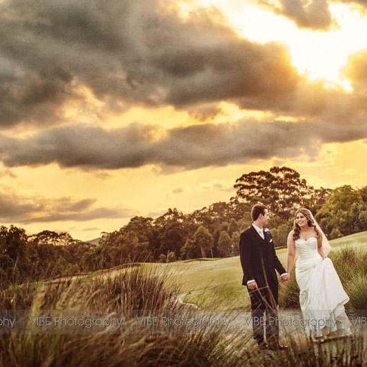 Bride and groom holding hands and walking at Mercure Kooindah Waters