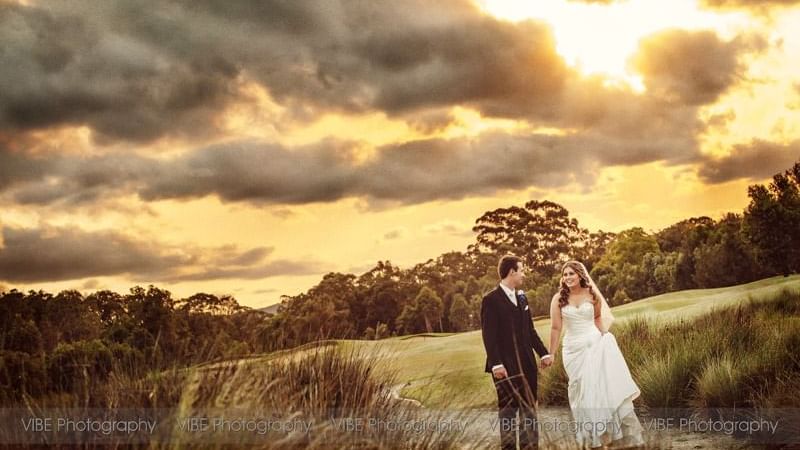 Bride and groom holding hands and walking at Mercure Kooindah Waters