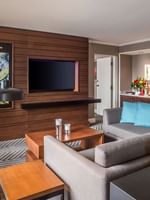 Emerald Suite a grey sofa by a wooden media wall under warm lighting at Warwick Seattle
