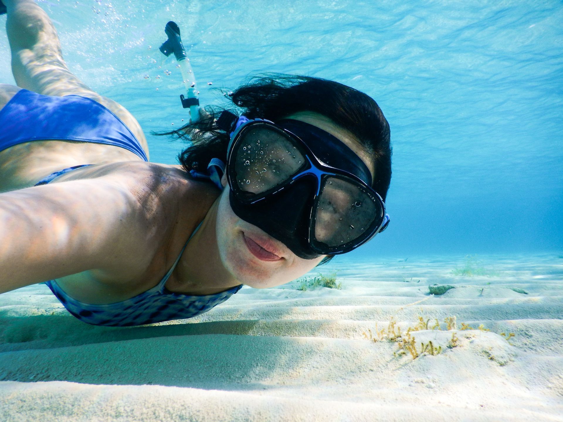 Woman with goggles diving in the sea near Villas Sol Beach Resort