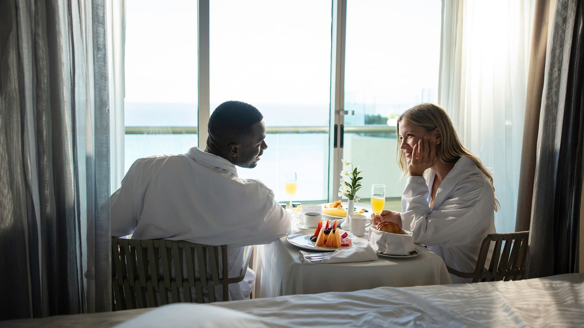 Two people at a breakfast table by a window in room at Live Aqua Resorts and Residence Club