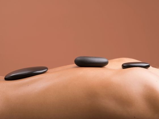 Close-up of spa stones on a body at Ana Hotels