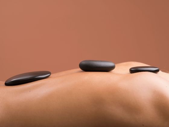 Close-up of lady having hot stone treatment at Ana Hotels