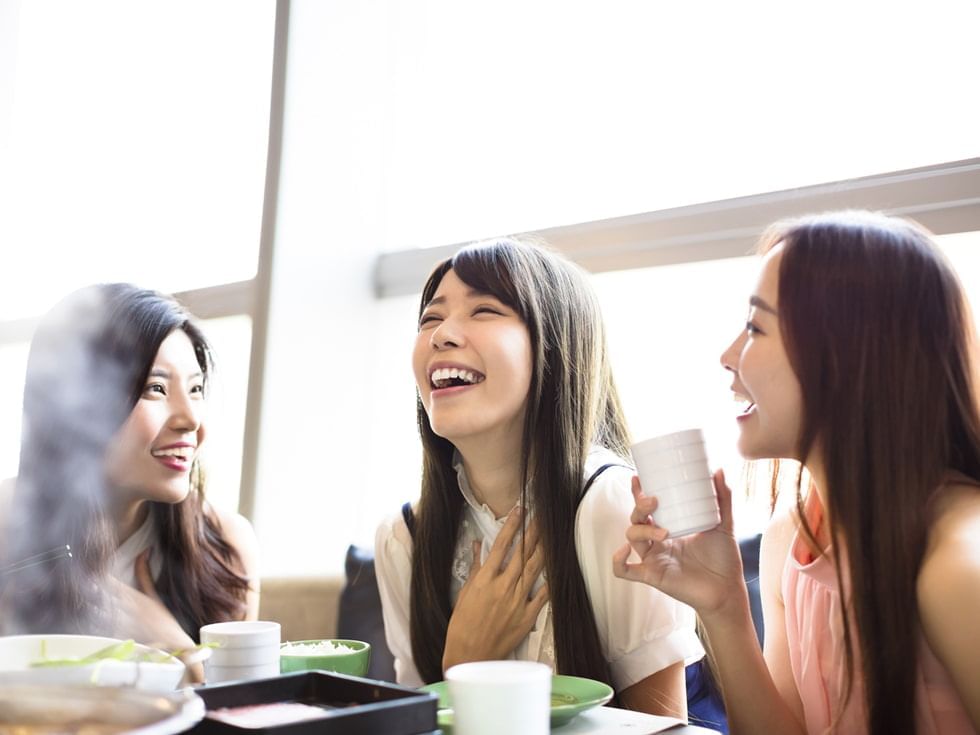 Three individuals with drinks engaged in conversation at Imperial Lexis Kuala Lumpur