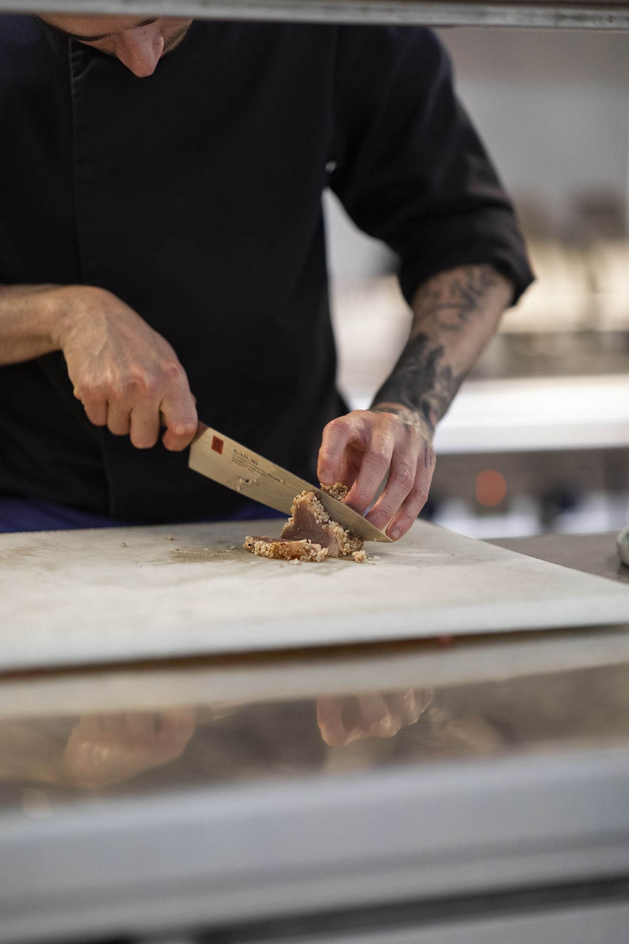 Gros plan sur un chef coupant de la nourriture sur une planche à découper à l'Oceania Paris Roissy CDG