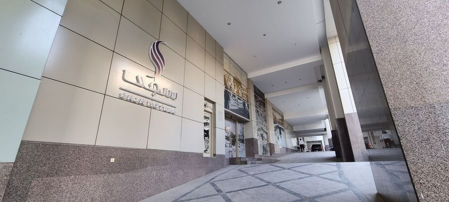 Grand entrance of Saja by Warwick Makkah featuring a large silver logo on a modern beige facade