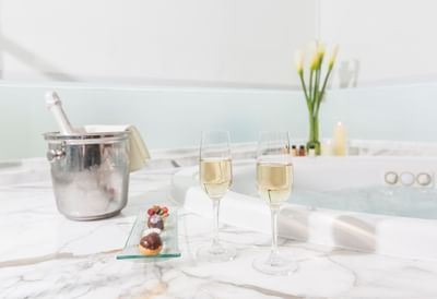 Two champagne flutes, gourmet desserts, and an ice bucket served by whirlpool tub of the spa at Hotel Los Delfines & Casino