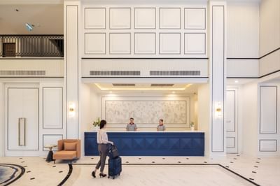 Guest checking in at the reception with luggage at Eastin Hotels