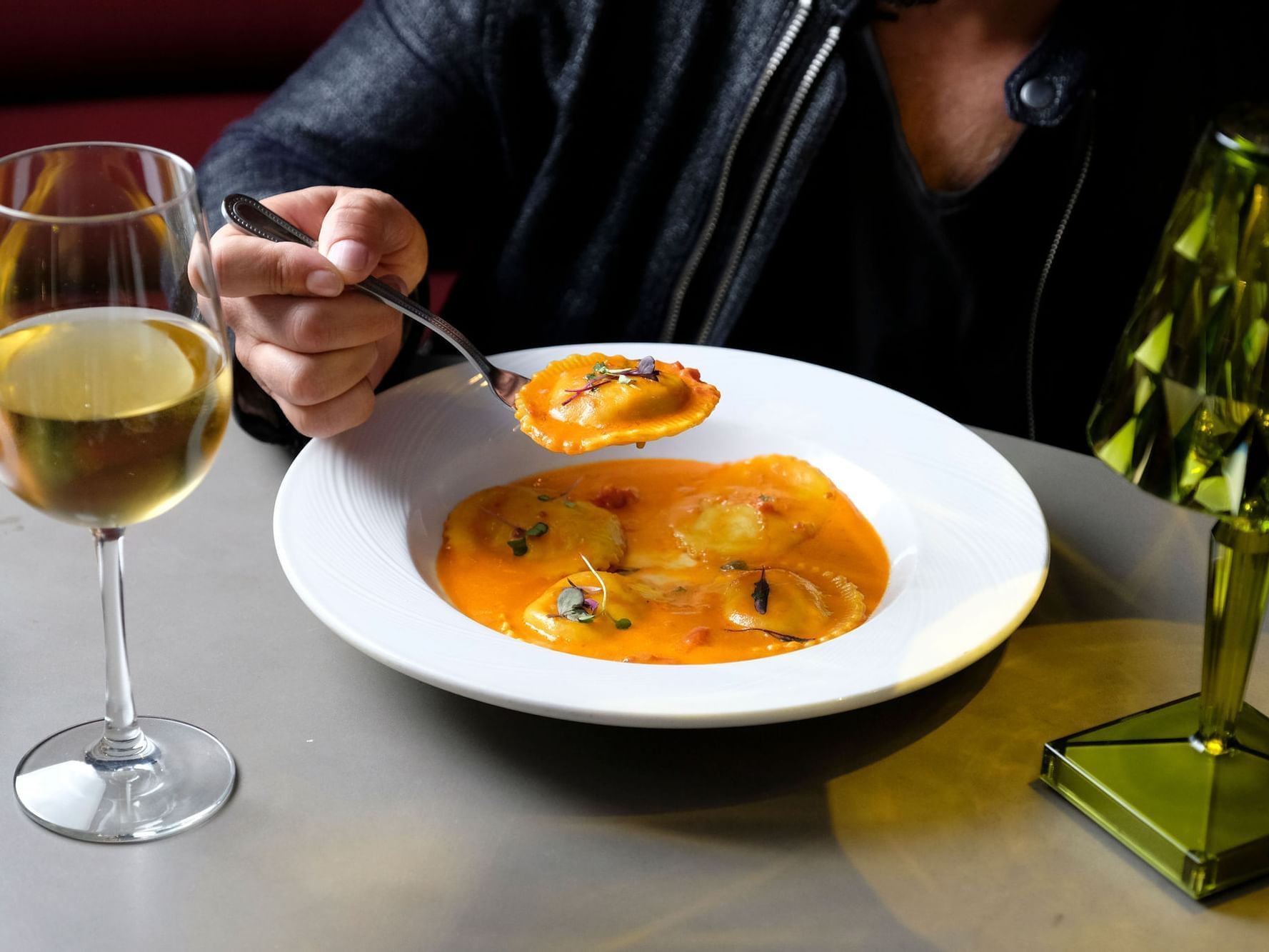 Man enjoying a dish with a glass of wine at Boulan South Beach