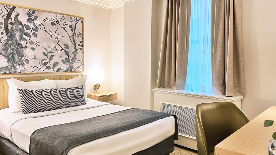 Bed with side tables & work desk near window in Petite Classic at Warwick Allerton Chicago