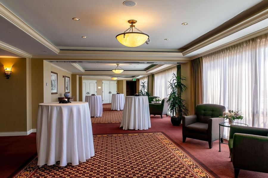 Cocktail tables with white cloths by an armchair under dome in Millennium at Warwick Denver
