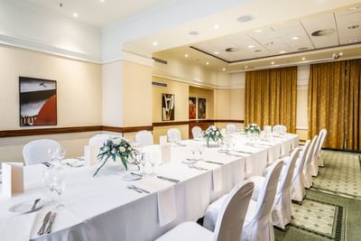Banquet hall with decorated dining tables and portraits on the wall at Polonia Palace