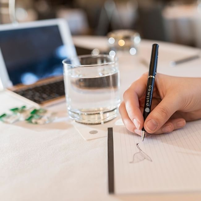 Woman jotting notes in a Meeting at Pullman Olympic Park