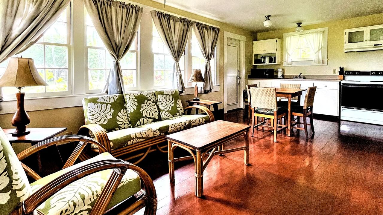 Living room with kitchen appliances, tables, couches, and chairs