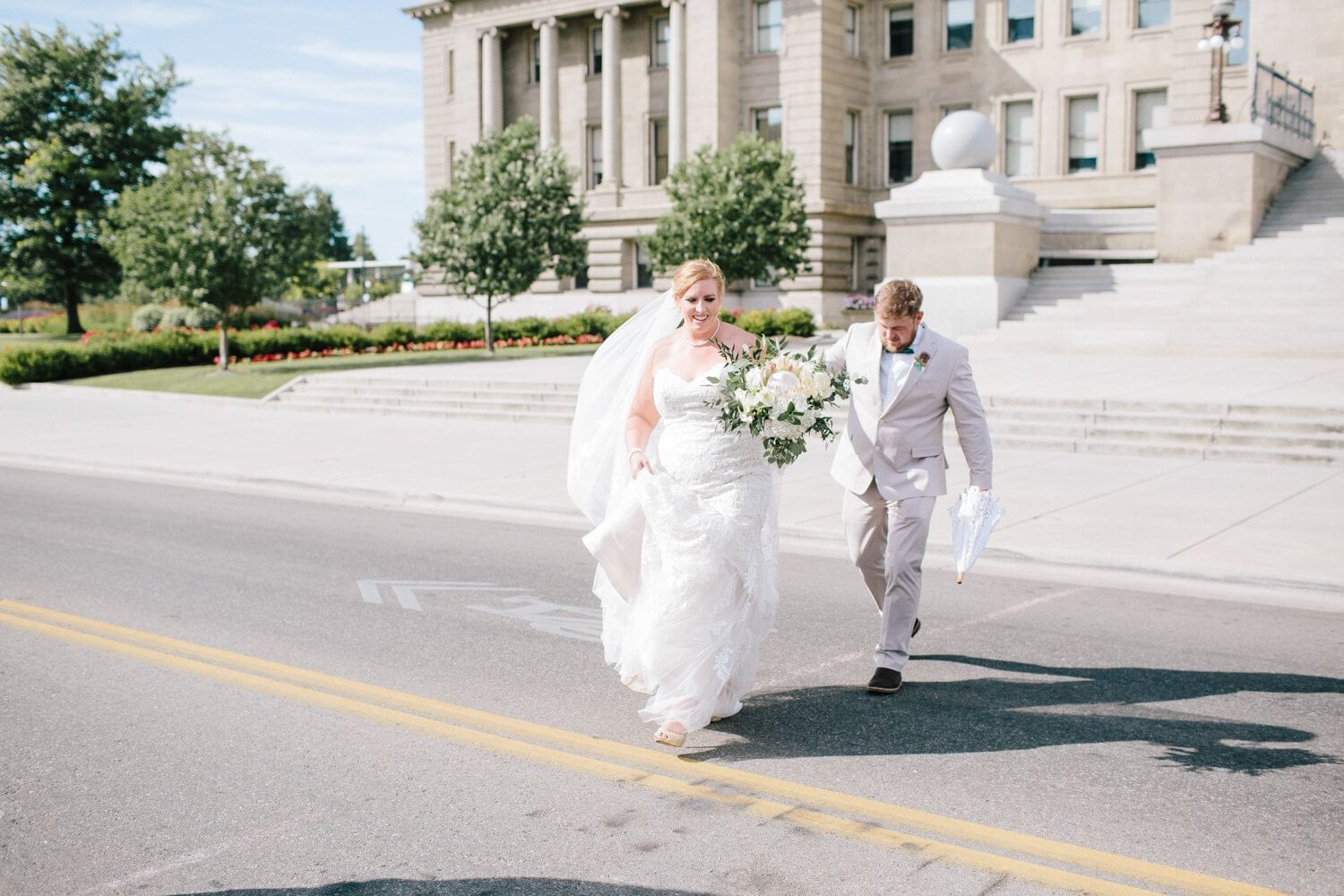 A bride & groom walking across a street at Grove Hotel