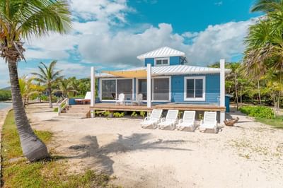 Bungalow with an exterior wooden deck and beach chairs at Barefoot Cay Resort & Marina