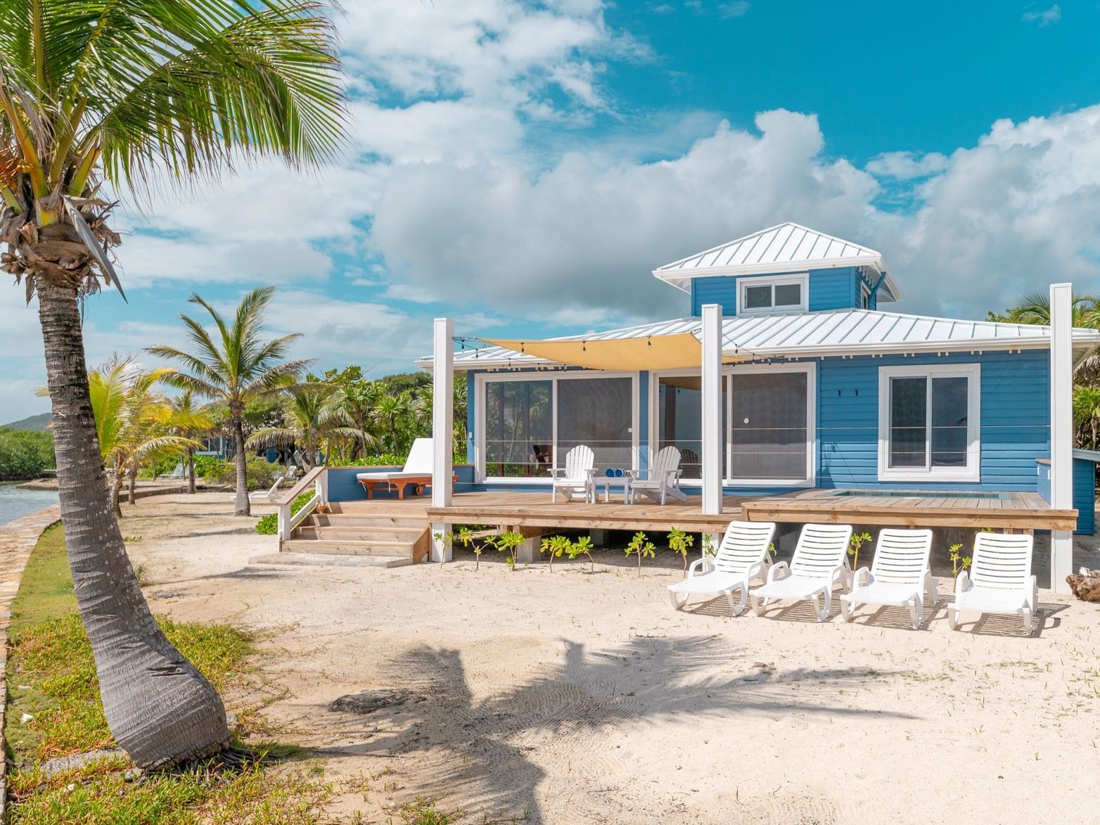 Grand Villa with a wooden deck and lounge chairs at Roatan, Honduras villa rentals Barefoot Cay Resort & Marina