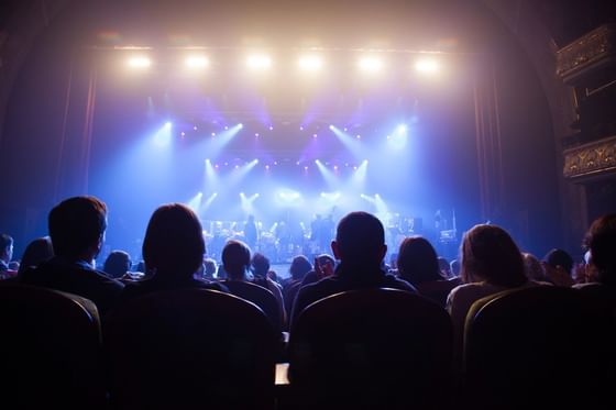 Concert crowd under spotlights near Paramount Hotel Seattle, a live show with a band in a historic theater