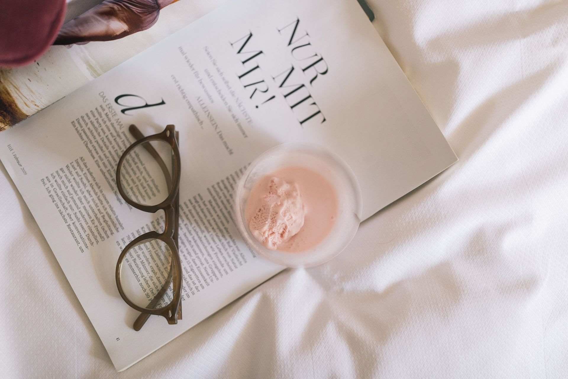 An ice-cream bowl & reading glasses by a magazine at Liebes Rot