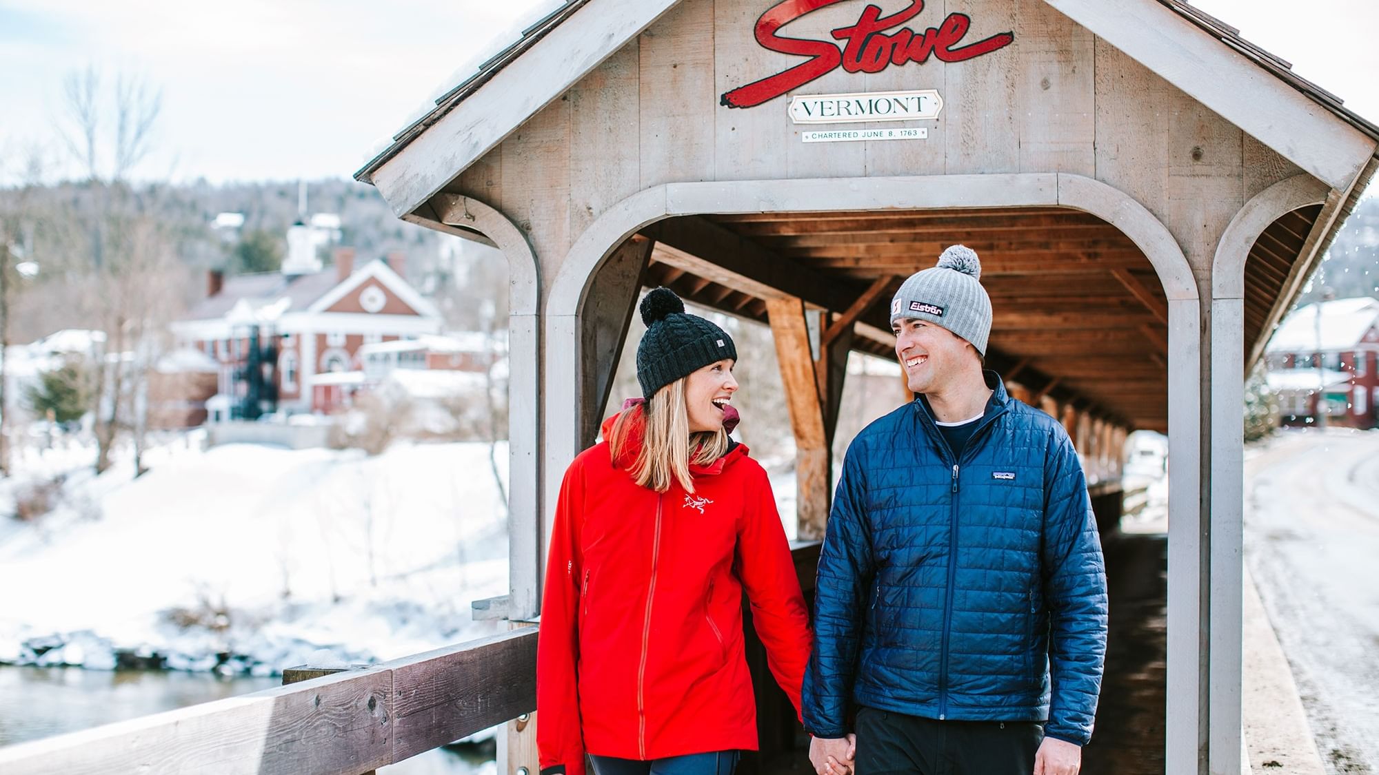 Couple holding hands under a covered bridge with 