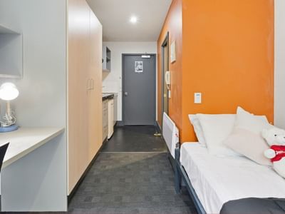 A clean, well-furnished student room with a desk, bed, and cabinets at Student Living Auckland - Beach.