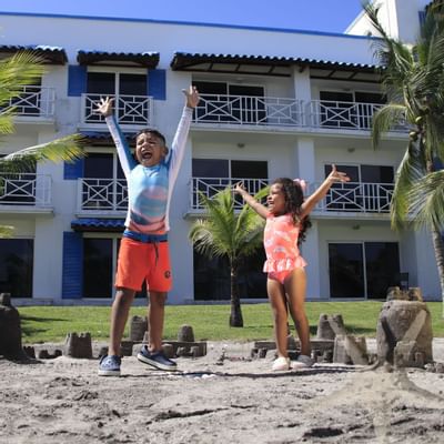 Two kids cheering in the play area at Playa Blanca Beach Resort