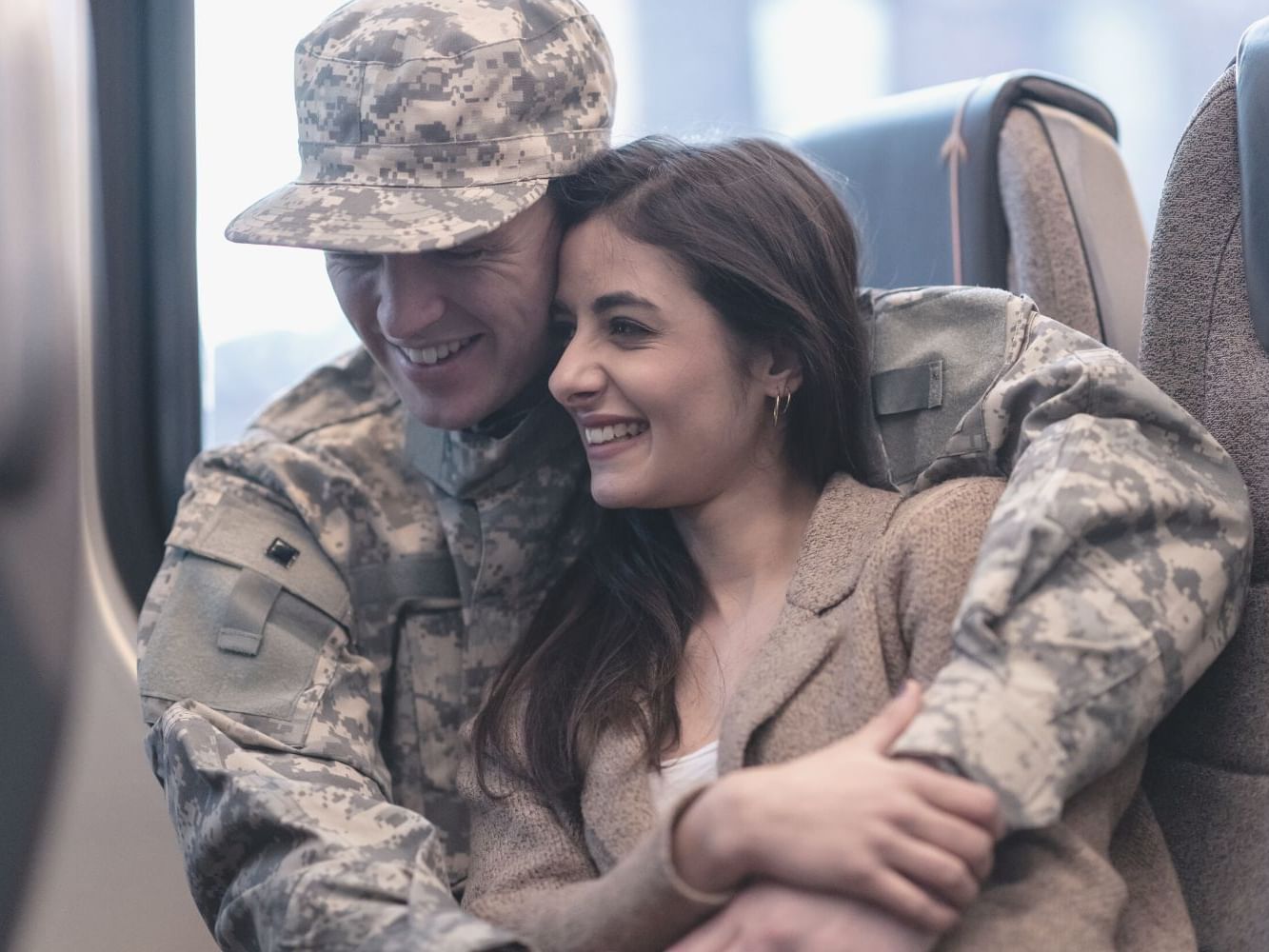 Person in military uniform embracing a lady on a bus seat near Waikiki Resort Hotel by Sono