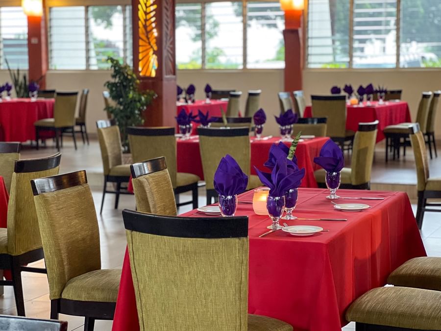Red-clothed dining tables featuring vibrant purple napkins in KanaVata Restaurant at TokaToka Resort Nadi Fiji