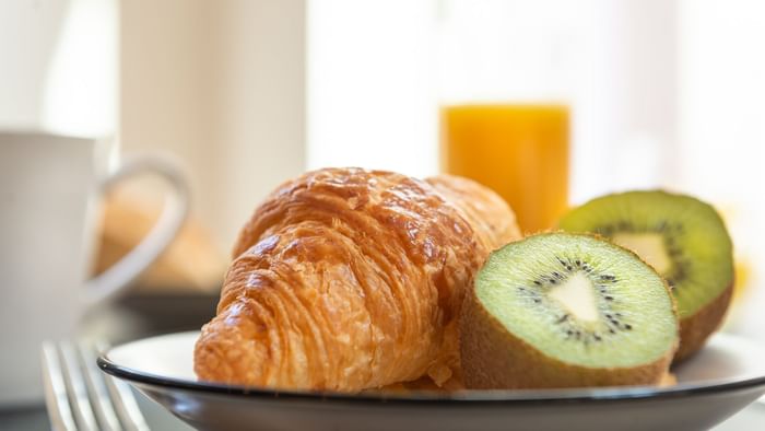 Close-up of a croissant & kiwi served at Residence Le Monde
