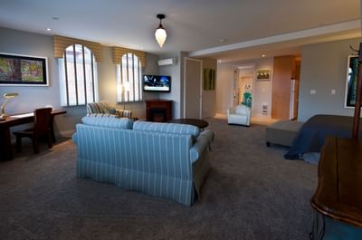 Living area with cozy sofa, TV & workspace in Apartment 202 at Retro Suites Hotel