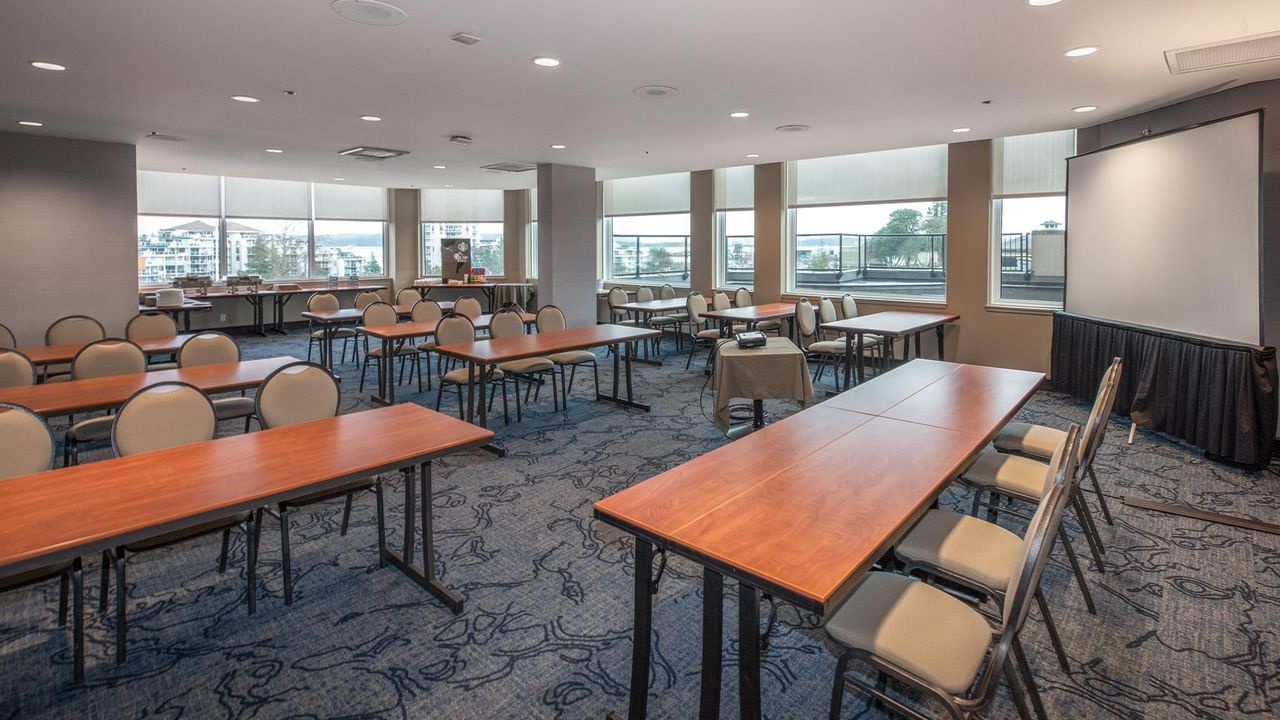A large conference room with tables and chairs at Coast Bastion Hotel.