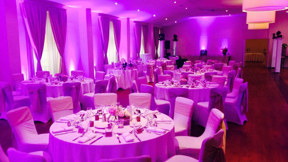 Salle de réception avec tables rondes couvertes de nappes 