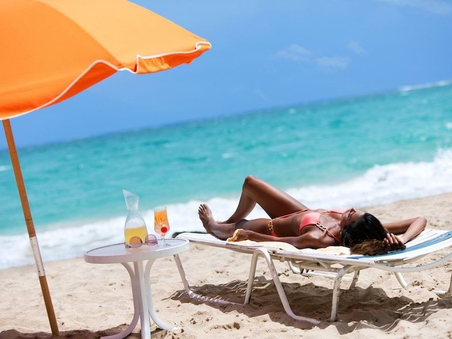woman laying on lounge chair at the beach
