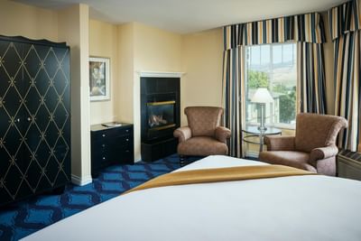 Sitting area with city view in ​the Fireplace King Non-View room of Plaza Inn & Suites at Ashland Creek​ 