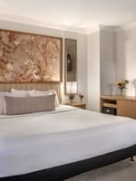Bed with work desk under hanging TV in Accessible Standard Room at Warwick Allerton Chicago
