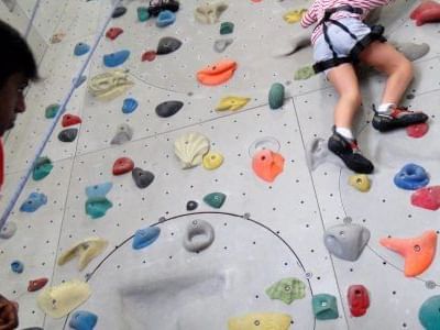 A person climbing on an indoor gym climbing wall in Camp5 Climbing Gym near One World Hotel