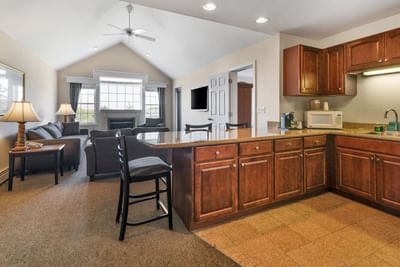 Cozy living space at Ogunquit Hotel and Suites with wood cabinets, a large window, and comfortable seating