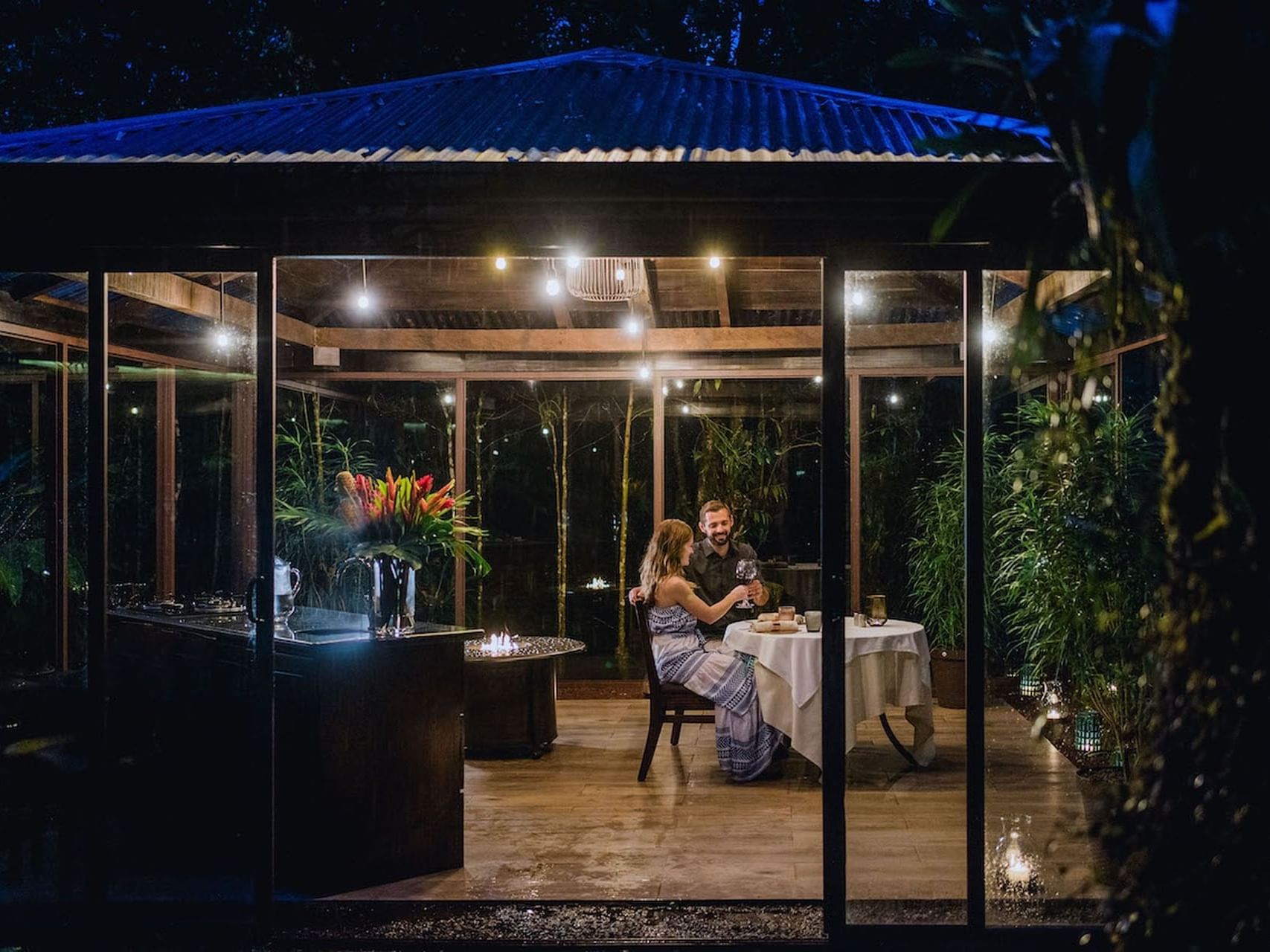 Couple toasting over a romantic dinner in Rancho Orquideas Private Dining area at El Silencio Lodge and Spa