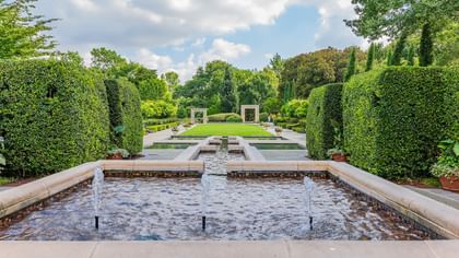 Serene water feature surrounded by greenery at Dallas Arboretum and Botanical Garden near Warwick Melrose Dallas