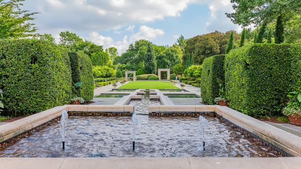 A serene water feature surrounded by greenery at Dallas Arboretum and Botanical Garden.