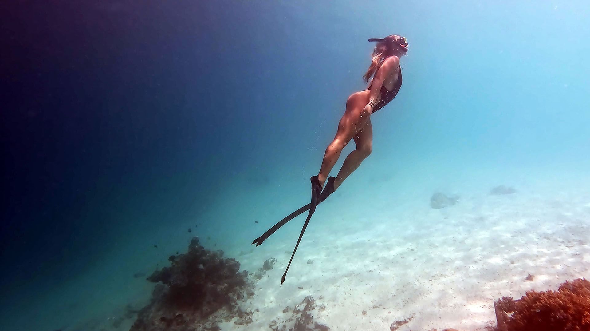 Freediver with fins ascending underwater near Grand Park Kodhipparu, Maldives